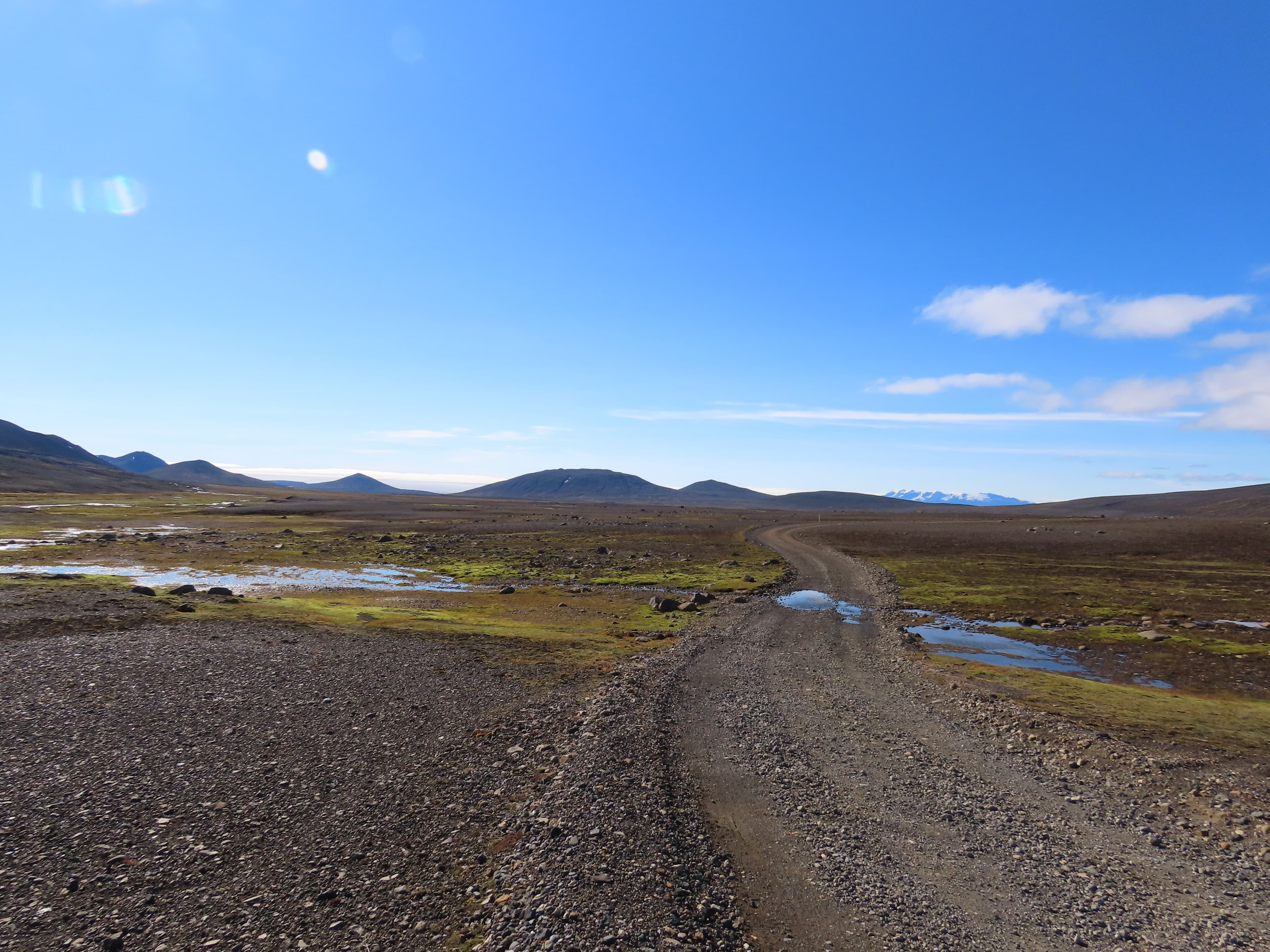 A gravel road crossing open country in Iceland