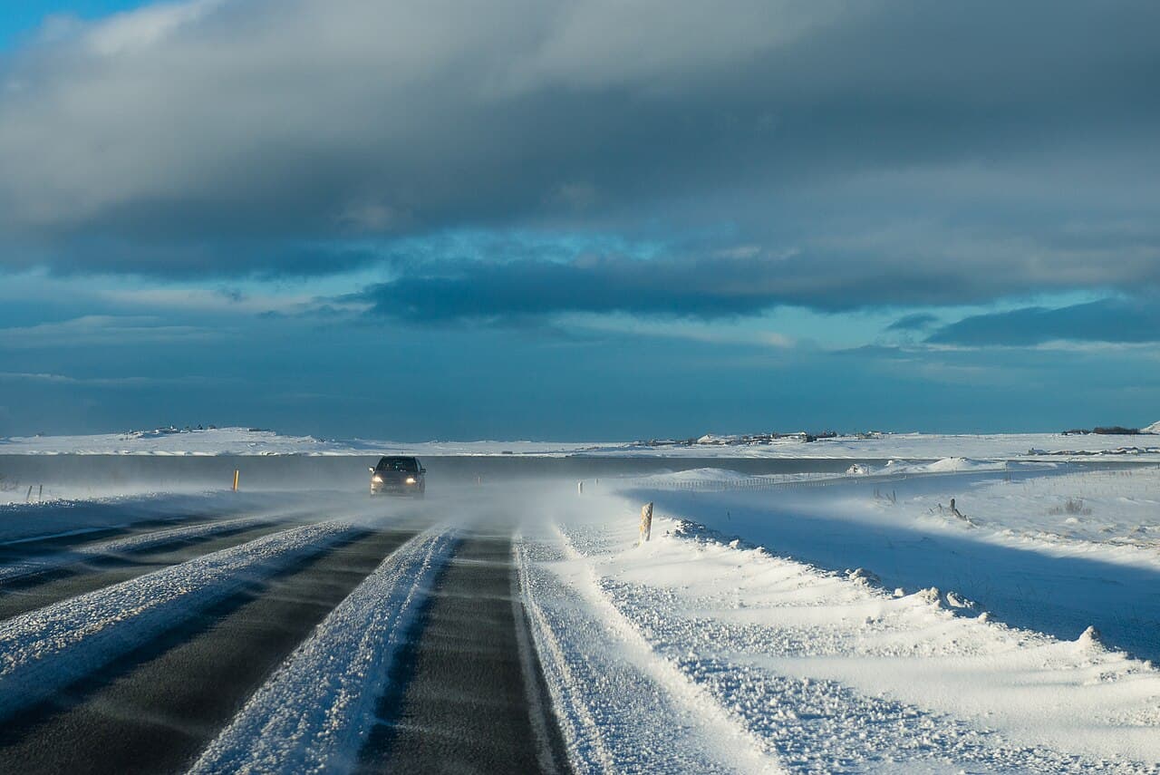 An icy Icelandic road surface with snow at the edges, showing winter driving conditions