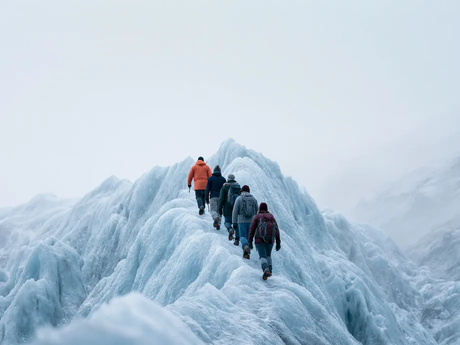 Hikers roped in single file on a blue glacier ridge in Iceland